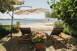 two chairs and a table with an umbrella on the beach at Apartments Lucija in Zadar