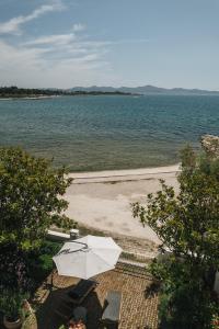 a beach with an umbrella and chairs and the water at Apartments Lucija in Zadar