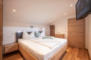 a bedroom with a large bed and a flat screen tv at Haus Schlechter in Mayrhofen