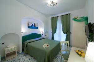 
a hotel room with a bed and a dresser at Hotel La Conchiglia in Praiano
