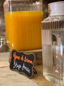 Pazo da Pena Manzaneda في مانزانيدا: ابريق زجاجي من عصير البرتقال بجانب جرة من عصير البرتقال