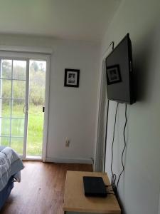 a bedroom with a television and a table with a bed at The becket Motel in Becket Center
