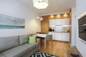 a living room and kitchen with a couch and a table at Central Apartments Rajska in Gdańsk