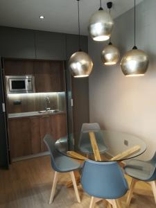 a dining room with a glass table and blue chairs at Aljibe Casa Rural in Algar