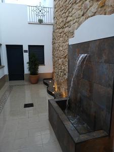 una fuente de agua en una habitación con una pared de piedra en Aljibe Casa Rural en Algar