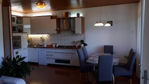 a kitchen with white cabinets and a table with chairs at Best4You Apartment - sea view - 70 m2 - 2 bedrooms in Dubrovnik