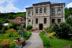 an old house with a garden in front of it at Country house Dunjin Konak in Rogljevo