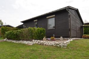 een zwart huis met een rotstuin ervoor bij Ferienhaus Hüfler 59 in Kelbra
