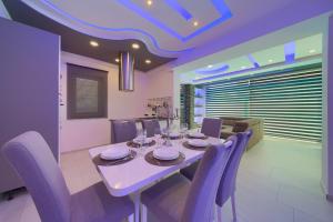 a dining room with a table and purple chairs at Luxury VALL Apartment in Krk