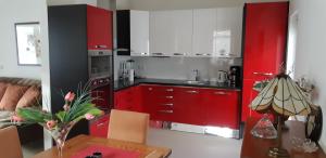 cocina con armarios rojos y mesa con lámpara en Casa Martin, en Porumbacu de Sus