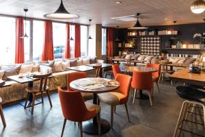 a restaurant with tables and couches and chairs at Hôtel L'Adresse in Saint Malo