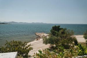 a group of people walking on a beach near the water at Apartments Lucija in Zadar