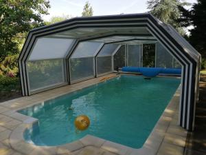 a swimming pool in a glass house at Chez Cyril et Vi in Saint-Règle