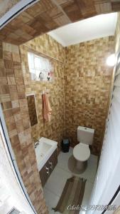 a small bathroom with a toilet and a sink at Casa de Férias Praia Grande in Praia Grande