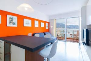 a living room with orange walls and a table and chairs at Terrazza Vista Mare, Parcheggio, Aria condizionata in Roquebrune-Cap-Martin