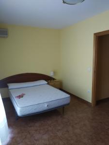 ein kleines Schlafzimmer mit einem Bett und einem Nachttisch in der Unterkunft Cal Músic in Antella