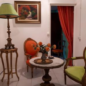 sala de estar con mesa, sillas y lámpara en TERRASSE DU PITON, en Deshaies
