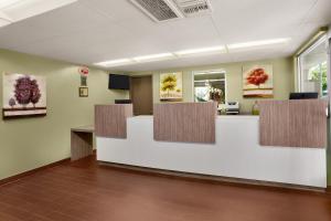 an office lobby with a reception desk and paintings on the wall at Kings Inn Anaheim at The Park & Convention Center in Anaheim