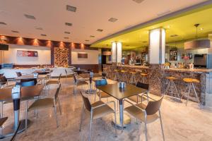 a restaurant with tables and chairs and a bar at Hotel Minso in Sanxenxo