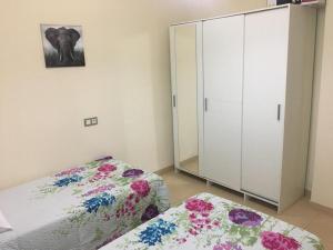 リンコン・デ・ラ・ビクトリアにあるLos Manzanosのベッドルーム1室(ベッド2台、白いキャビネット付)