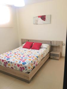 リンコン・デ・ラ・ビクトリアにあるLos Manzanosのベッドルーム1室(赤い枕2つ付)