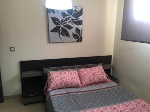 リンコン・デ・ラ・ビクトリアにあるLos Manzanosのピンクの枕が付くベッドが備わる小さなベッドルーム1室