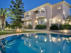 a large house with a swimming pool in front of it at San Giorgios Maisonettes in Laganas