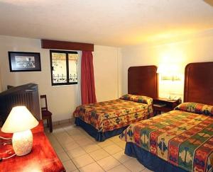 Habitación de hotel con 2 camas y mesa en Hotel Calenda, en Oaxaca City