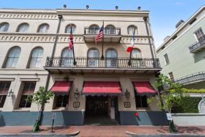 un edificio con balcón y dos banderas. en Prince Conti Hotel en Nueva Orleans