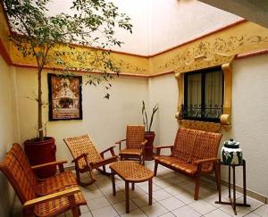 un grupo de sillas de mimbre sentadas en un patio en Hotel Calenda, en Oaxaca City