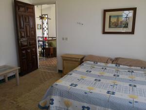 una camera con un letto e un piumone blu e bianco di RIAD DES OISEAUX a El Aouamra