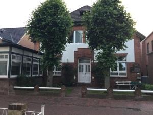 ein Haus mit zwei Bäumen davor in der Unterkunft Gästehaus Sophie Randa in Borkum