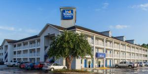ein großes Gebäude mit einem Hotelshuttleschild darauf in der Unterkunft InTown Suites Extended Stay Jacksonville FL - Beach Blvd in Jacksonville