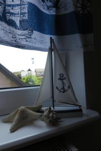 a toy sail boat sitting on a window sill at Pokoje na Falistej in Mechelinki