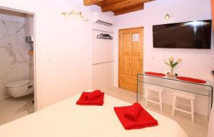 ドゥブロヴニクにあるAngelus Roomsのバスルーム(赤いタオルを使用したカウンター、テレビ付)