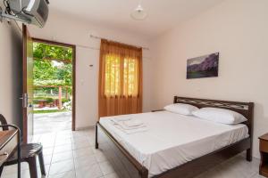 a bedroom with a bed and a sliding glass door at Litochoro Rooms in Plaka Litochorou