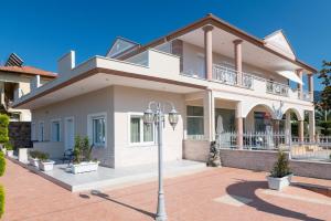 a large white house with a street light in front of it at Polyxeni's Studios in Limenas