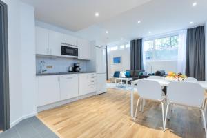a kitchen and living room with a table and chairs at ApartDirect Sundbyberg in Sundbyberg