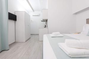 a white room with two beds and a table at Polyxeni's Studios in Limenas