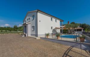 a building with a swimming pool next to a house at Silver Holiday House in Poreč +4 photos