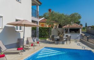 a villa with a swimming pool and a table and chairs at Silver Holiday House in Poreč