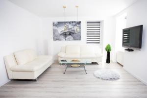 salon z białą kanapą i telewizorem w obiekcie Villa Hillside Apartment w mieście Jesenice