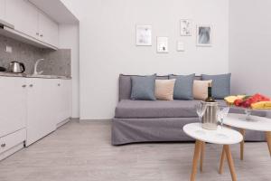 uma sala de estar com um sofá e duas mesas em Polyxeni's Studios em Thásos