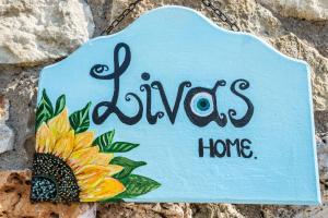 Ein Schild hängt an einer Wand mit Sonnenblume in der Unterkunft Villa Livas in Kávallos