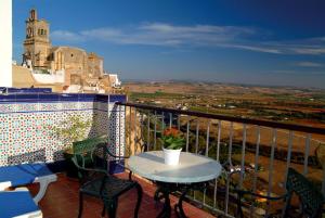 eine Terrasse mit einem Tisch und Stühlen auf dem Balkon in der Unterkunft Hotel El Convento in Arcos de la Frontera