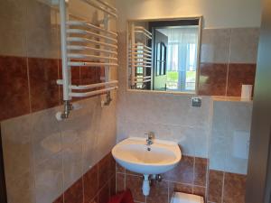 a bathroom with a sink and a mirror at POKOJE U MIKOŁAJA in Kamień Pomorski +13 photos