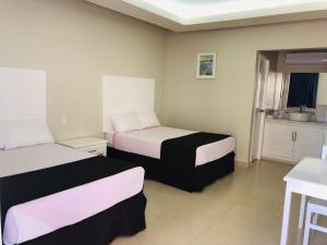 ein Hotelzimmer mit zwei Betten und einer Küche in der Unterkunft HOTEL VICTORIA in Ciudad Constitución + 6 Fotos