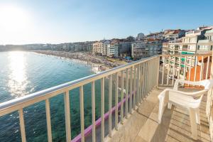 a balcony with a view of the beach and buildings at Hotel Minso in Sanxenxo