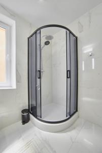 a bathroom with a shower with a large mirror at Apartament Lelewela 8 in Olsztyn