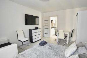 1 dormitorio con 1 cama, mesa y sillas en Apartament Lelewela 8 en Olsztyn